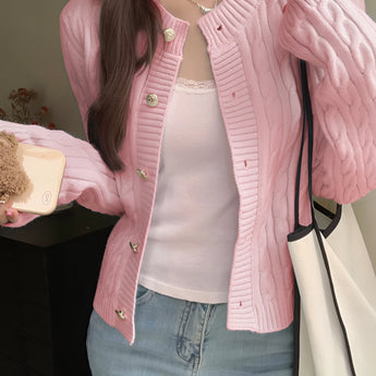 Stylish women's black quilted bomber jacket with gold button detail, featuring a sleek design and visible stitching on the fabric, worn by a model showcasing the shoulder and sleeve areas.
