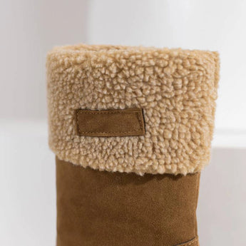 Tan suede winter boots for women with shearling lining, showcasing fashion-forward design and natural material in a stylish brown and beige color palette.