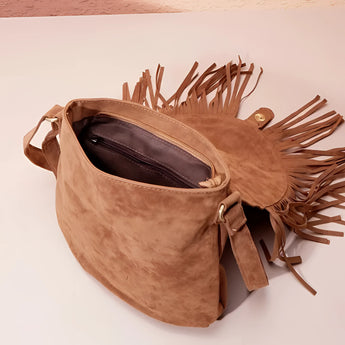 
Tan suede crossbody bag with fringe tassels, featuring a boho design.