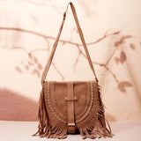 Tan suede crossbody bag with fringe tassels, featuring a boho style ideal for festivals.