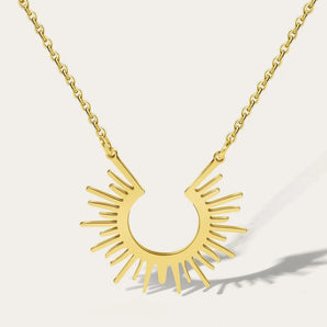 Gold Sunburst Pendant Necklace by YA-CHAN featuring a celestial design on a gold chain, styled around the neck.