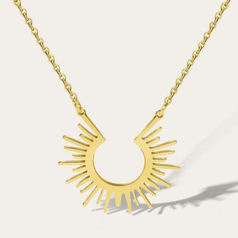 Gold Sunburst Pendant Necklace by YA-CHAN featuring a celestial design on a gold chain, styled around the neck.