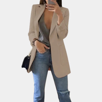 Women's tailored blazer in khaki, featuring a chic design suitable for office wear, with structured shoulders, long sleeves, and a three-button closure. Styled with jeans and sunglasses for a versatile look.