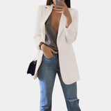 Tailored black blazer for women, styled for a chic office look, featuring a structured shoulder and long sleeves. The model is wearing sunglasses and has one hand on her waist, showcasing the versatile fit of the blazer.