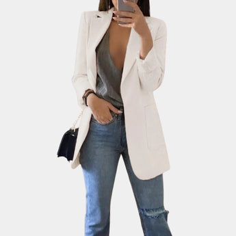Tailored black blazer for women, styled for a chic office look, featuring a structured shoulder and long sleeves. The model is wearing sunglasses and has one hand on her waist, showcasing the versatile fit of the blazer.