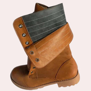 Tan leather boots featuring a contrast strap and rugged sole, showcasing a stylish and durable design.