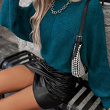 Teal cropped sweater paired with a black faux leather mini skirt, showcasing a stylish fall fashion look for women.