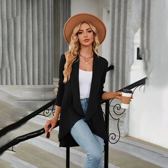 Teal long sleeve knit cardigan worn by a model, showcasing its shoulder and waist fit. The cardigan is styled with a sun hat and sunglasses, perfect for a trendy fall fashion look.