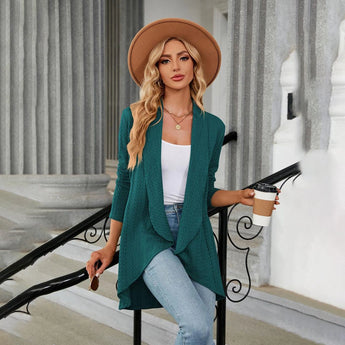 Teal long sleeve knit cardigan worn by a model, showcasing its fall fashion design with emphasis on shoulder, sleeve, and waist detailing. The cardigan appears to be part of a chic layered outfit suitable for cooler weather.