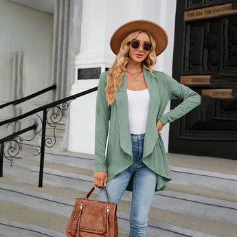 Teal long sleeve knit cardigan worn by a model, styled with a white fedora hat and sunglasses, showcasing a fall fashion layering piece.