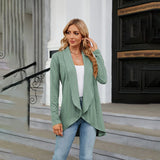 Teal long sleeve knit cardigan worn over a white dress shirt, paired with jeans. The cardigan features a classic collar and is styled as a fashionable fall layering piece.