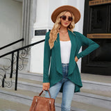 Teal long sleeve knit cardigan worn over a white top, paired with a stylish fedora hat and sunglasses, showcasing a fashionable fall layering look.