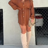 Teal oversized shirt dress styled with brown thigh-high suede boots, model wearing sunglasses.
