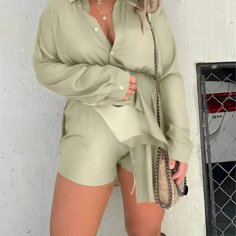 
A woman wearing a teal oversized shirt dress paired with thigh-high suede boots, accessorized with sunglasses.