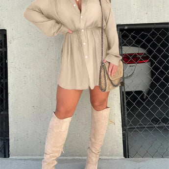 
A woman wearing a teal oversized shirt dress paired with thigh-high suede boots. She is accessorized with eyewear and has long hair. The outfit style is casual chic.