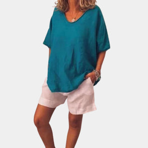 Teal oversized linen blouse with a V-neck design, featuring short sleeves. The tunic is styled for casual summer wear and is shown in a blue color, size 3XL.