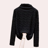 Women's high-collar top in black with a textured floral embossed pattern, featuring long sleeves and a sophisticated design.