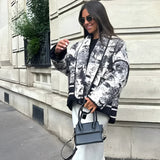 Textured bomber jacket in black, size large, featuring a stylish monochrome design perfect for winter street style; person wearing dark sunglasses and standing with hands in pockets.