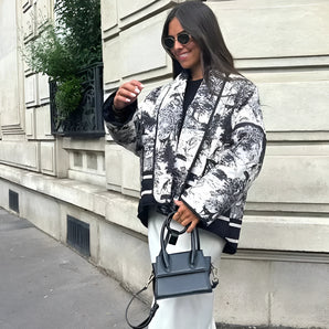 Textured bomber jacket in black, size large, featuring a stylish monochrome design perfect for winter street style; person wearing dark sunglasses and standing with hands in pockets.