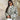 Textured bomber jacket in light green with a patterned design, worn by a person accessorized with sunglasses, showcasing a stylish monochrome winter street style.