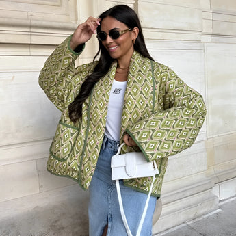 Textured bomber jacket in green patterned design, worn by a person with sunglasses, showcasing a stylish monochrome winter street style with a focus on outerwear fashion.
