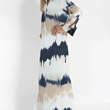 Tie-dye maxi dress featuring a keyhole neckline, long sleeves, and a fitted waist, showcasing a blend of vibrant colors ideal for elegant fall fashion.