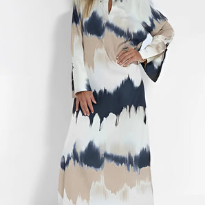 Elegant tie-dye maxi dress featuring a keyhole neckline, showcasing a vibrant fall fashion print against a backdrop of natural elements.