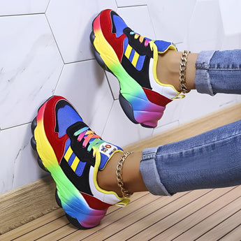 
A pair of trendy multicolor sneakers with a vibrant rainbow sole, displayed on a model with blue sneakers in size 43. The focus is on the stylish and contemporary design of the shoes.