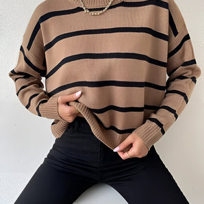 Trendy tan and black striped crew neck sweater modeled, showcasing fall fashion with a focus on upper body and shoulder area.