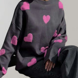 Trendy women's cozy pullover featuring a grey and pink heart pattern, shown in black-pink colorway and size large, with long sleeves and a comfortable fit.