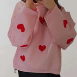 Trendy women's cozy pullover in grey and pink featuring a heart pattern, shown in size large. The pullover has long sleeves and a round neck, designed for a stylish and comfortable fit.