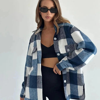 Trendy women's oversized plaid jacket in grey, featuring a collared neckline and long sleeves, styled for chic autumn streetwear. The model wears sunglasses, accentuating the fashionable outerwear look.
