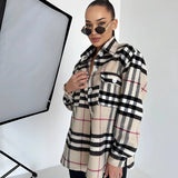 Stylish woman wearing an oversized plaid jacket with a tartan pattern, complemented by sunglasses, embodying chic autumn streetwear.