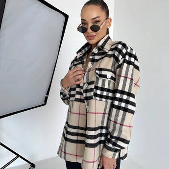Stylish woman wearing an oversized plaid jacket with a tartan pattern, complemented by sunglasses, embodying chic autumn streetwear.