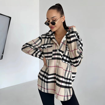 Oversized plaid jacket worn by a woman featuring a chic tartan pattern, with long sleeves, and styled as trendy autumn streetwear. The woman is wearing sunglasses and making a casual gesture, highlighting the jacket's relaxed fit around the shoulders and waist.