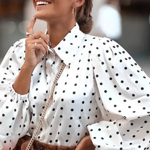 Oversized white polka dot blouse worn by a woman, showcasing the fashion of a trendy, loose-fitting top with long sleeves, highlighting the shoulder and arm area, in size 3XL.