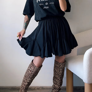 Trendy women's urban chic outfit featuring a black tee, pleated skirt, and leopard print boots.