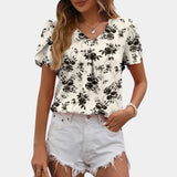 Black and white floral V-neck blouse with short sleeves, designed for a casual summer look, shown in the color variant "Wit" and size XL.