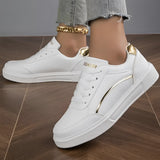 Trendy women's white low-top sneakers with gold accents, featuring a stylish and sporty design, perfect for casual wear and walking.