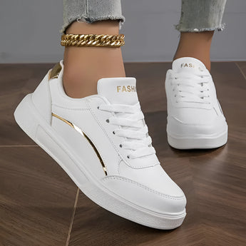 Trendy women's white low-top sneakers featuring gold accents, designed for a fashionable and sporty look.