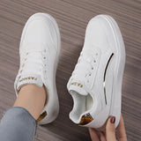 Trendy women's white low-top sneakers with gold accents showcasing a stylish design, suitable for outdoor activities and sportswear.