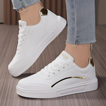 White low-top sneakers for women with gold accents, featuring a stylish and trendy design suitable for walking and fashion-forward outfits.