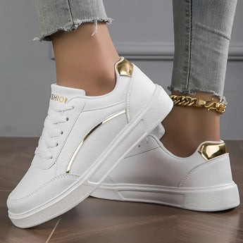 
White low-top sneakers for women featuring stylish gold accents, shown against a neutral background.
