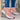 Trendy women's white sneakers with bold pink soles, shown in a size 43, worn by a person, highlighting the fashionable and vibrant design.