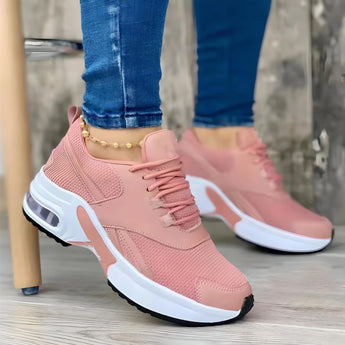 Trendy women's white sneakers with bold pink soles, shown in a size 43, worn by a person, highlighting the fashionable and vibrant design.