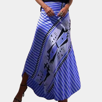Bohemian maxi skirt with a tribal print design in a yellow striped pattern, featuring a wrap style. The skirt is paired with a blue top and is worn by a person with a blue bag.