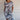 
A woman wearing a white tropical botanical print sleeveless summer shift dress, perfect for beachwear, in size 3XL. The dress features a relaxed fit with a round neckline and falls above the knee.