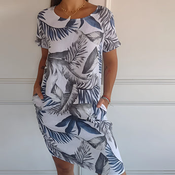 
A woman wearing a white tropical botanical print sleeveless summer shift dress, perfect for beachwear, in size 3XL. The dress features a relaxed fit with a round neckline and falls above the knee.