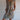 
A person wearing a tropical botanical print sleeveless summer shift dress in brown, suitable for beachwear, featuring a relaxed fit and lightweight fabric.
