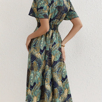 Tropical Leaf V-Neck Mini Dress with short sleeves, featuring a vibrant bohemian pattern, displayed on a mannequin highlighting its day dress style and summer resort wear appeal.